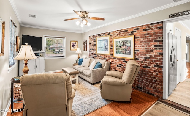 906 Belleview Cir E, Beaufort, SC 29902 - living room featuring wood finished floors, ceiling fan, brick wall, crown molding, and baseboards