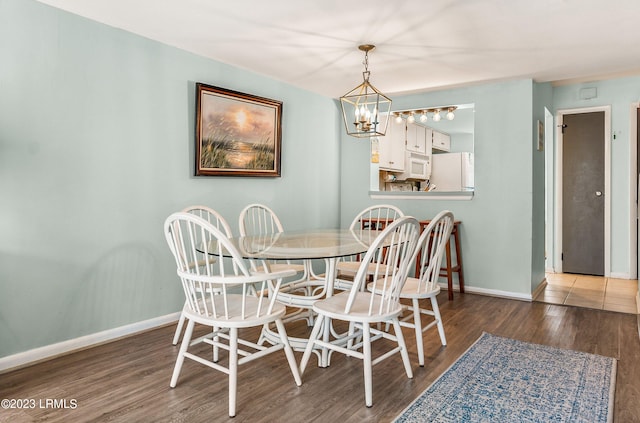 dining area featuring dark hardwood / wood-style flooring and a chandelier