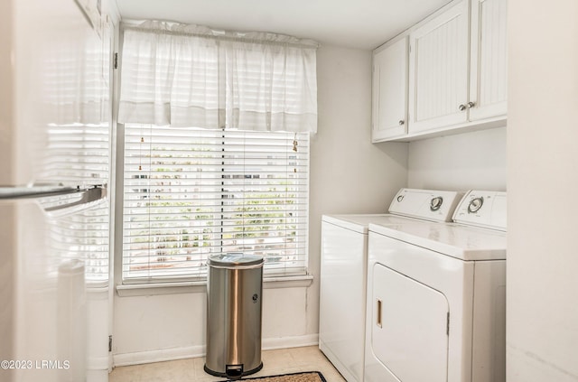 laundry area featuring cabinets, washer and dryer, and light tile patterned floors