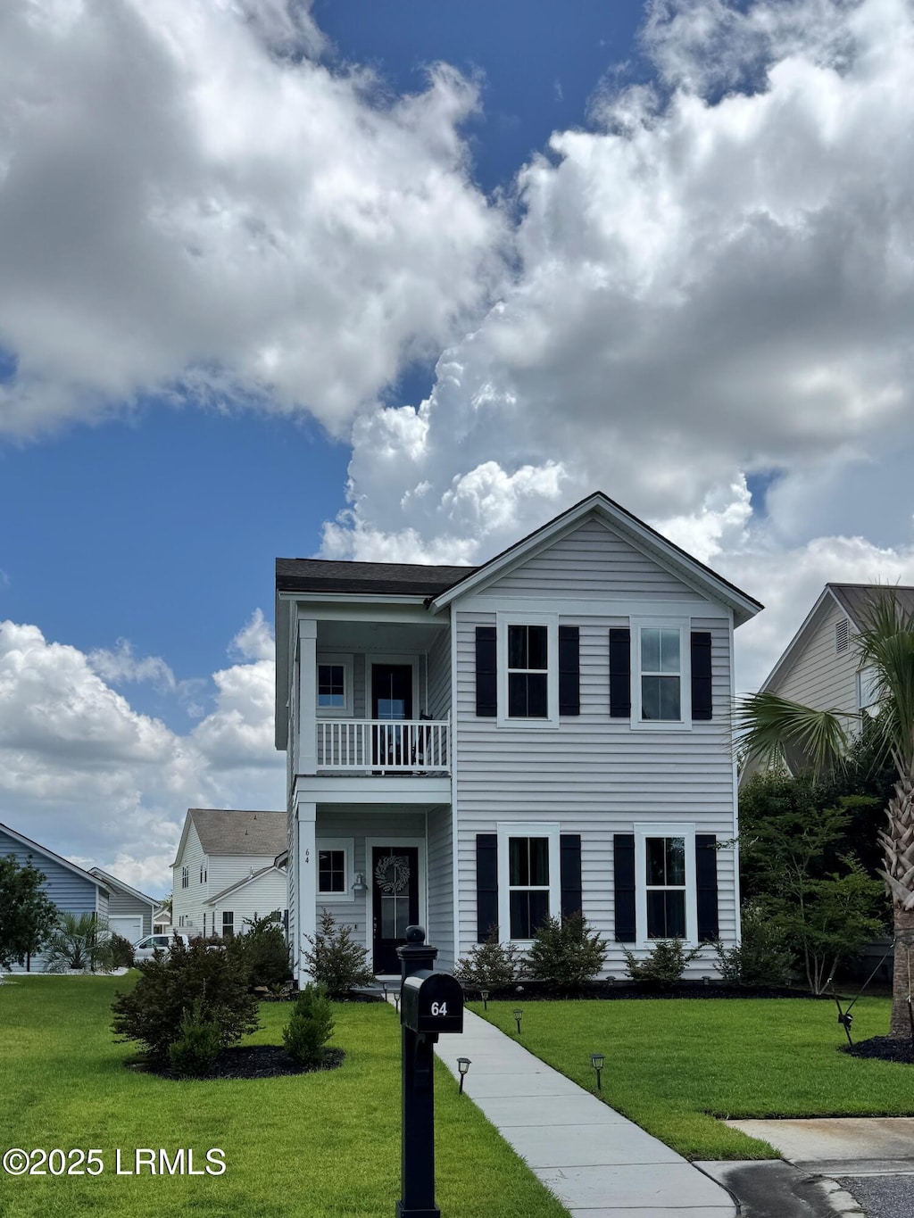 64 Hawthorn Ln, Hardeeville, SC 29927 - view of front facade featuring a balcony and a front lawn