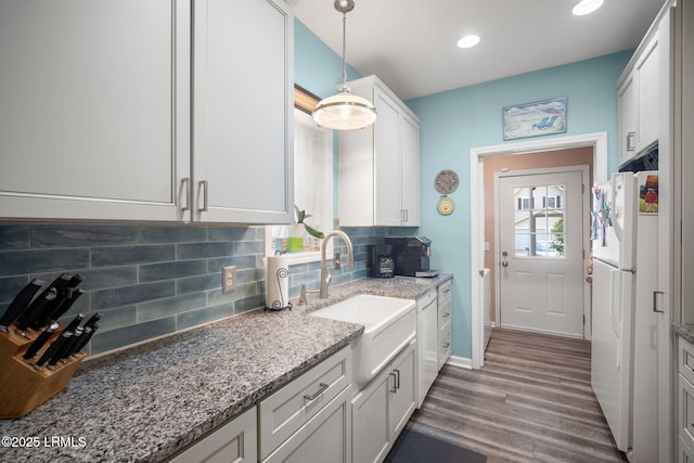 5 Regent Ave, Bluffton, SC 29910 - kitchen featuring white appliances, backsplash, wood finished floors, light stone countertops, and hanging light fixtures
