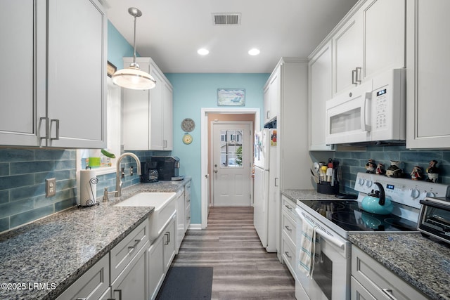 5 Regent Ave, Bluffton, SC 29910 - kitchen featuring white appliances, wood finished floors, decorative backsplash, light stone counters, and pendant lighting