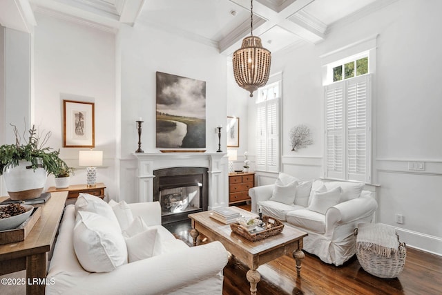 living room featuring beam ceiling, crown molding, a glass covered fireplace, wood finished floors, and coffered ceiling