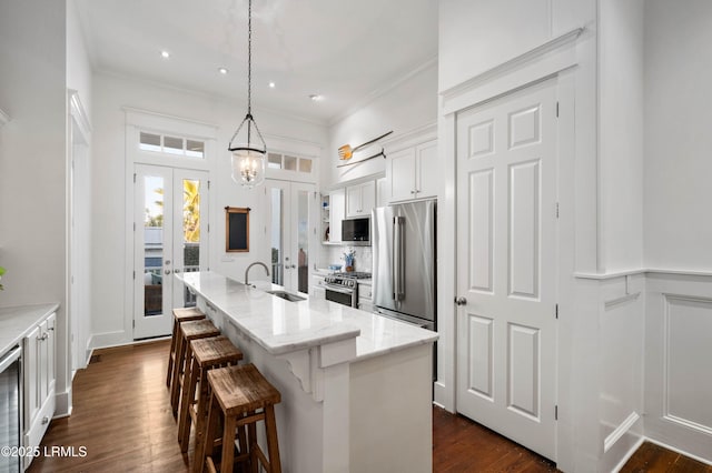 kitchen with crown molding, stainless steel appliances, a sink, and french doors