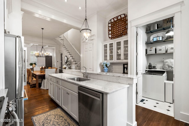 kitchen featuring crown molding, stainless steel appliances, a sink, and a notable chandelier