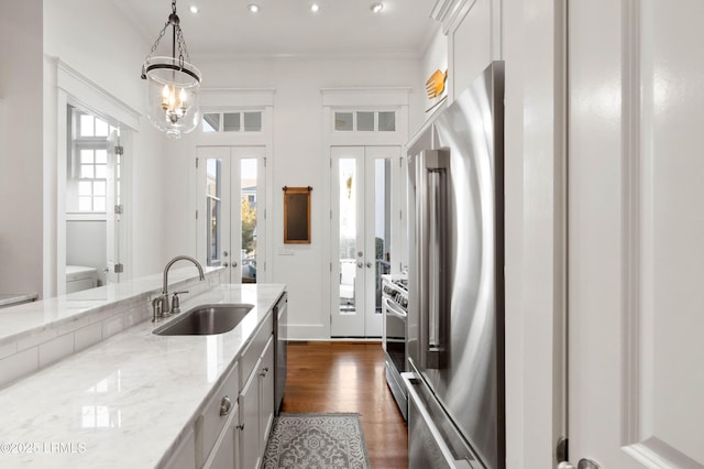 kitchen featuring stainless steel appliances, a sink, ornamental molding, french doors, and dark wood finished floors