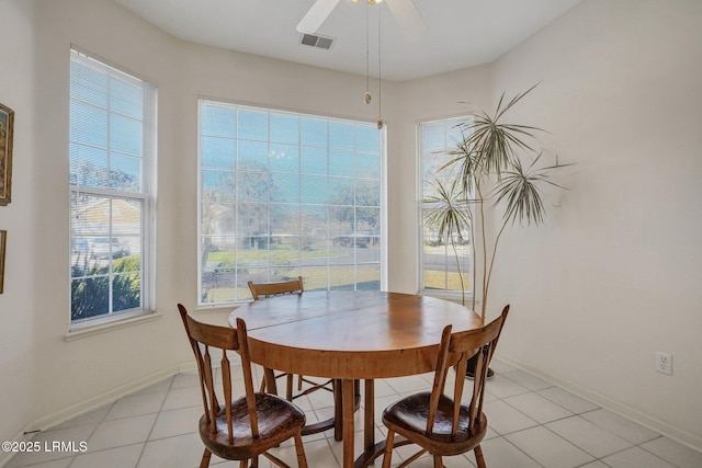 dining area with light tile patterned flooring, visible vents, ceiling fan, and baseboards