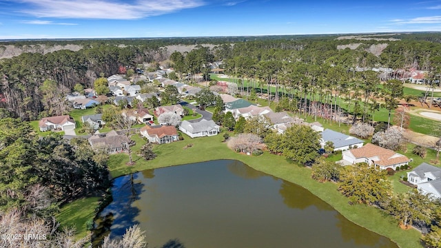 aerial view featuring a residential view, a wooded view, and a water view