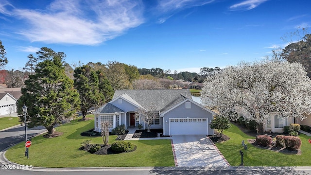 view of front of house featuring a garage, concrete driveway, and a front lawn