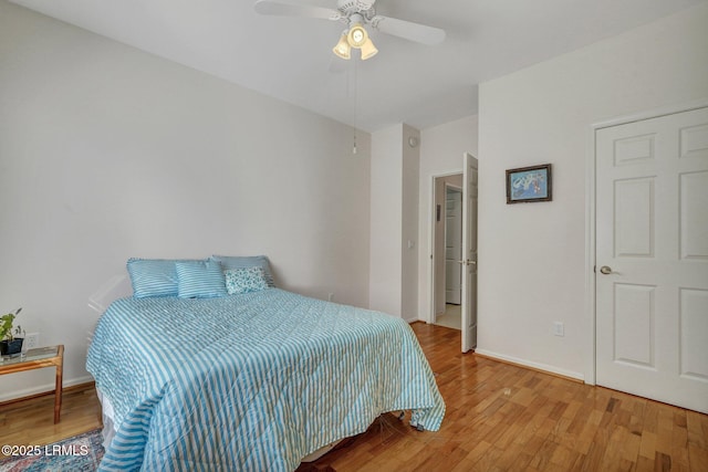 bedroom with light wood finished floors, a ceiling fan, and baseboards