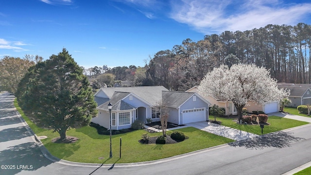 view of front of property featuring a front yard, a garage, and concrete driveway