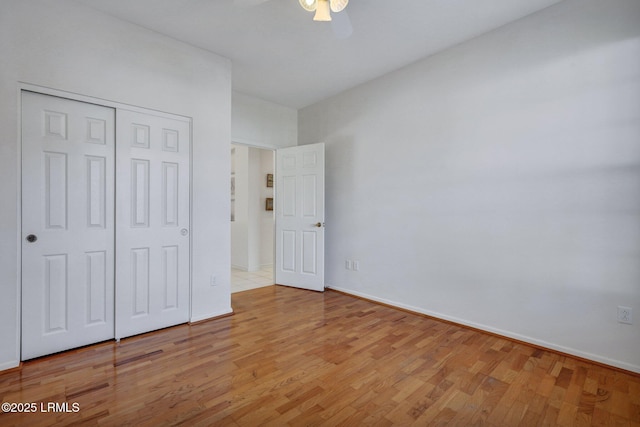 unfurnished bedroom featuring a closet, baseboards, and light wood-style floors