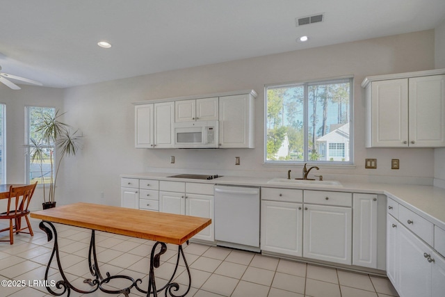 kitchen featuring a sink, visible vents, white appliances, and light tile patterned floors