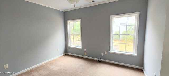 carpeted empty room with baseboards, ceiling fan, and crown molding