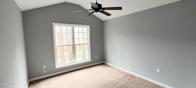 carpeted spare room featuring a ceiling fan, baseboards, and vaulted ceiling