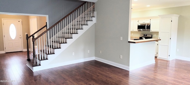 foyer featuring stairway, baseboards, and dark wood-style floors