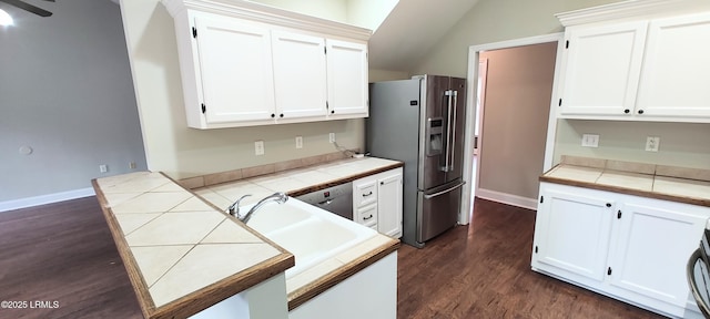 kitchen with tile countertops, a peninsula, dark wood-style flooring, white cabinets, and appliances with stainless steel finishes