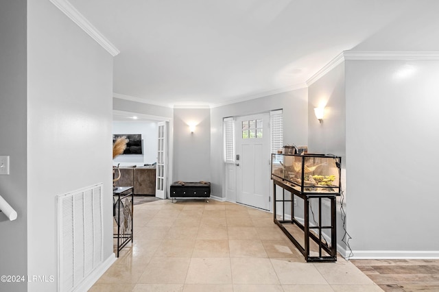 tiled foyer entrance featuring crown molding