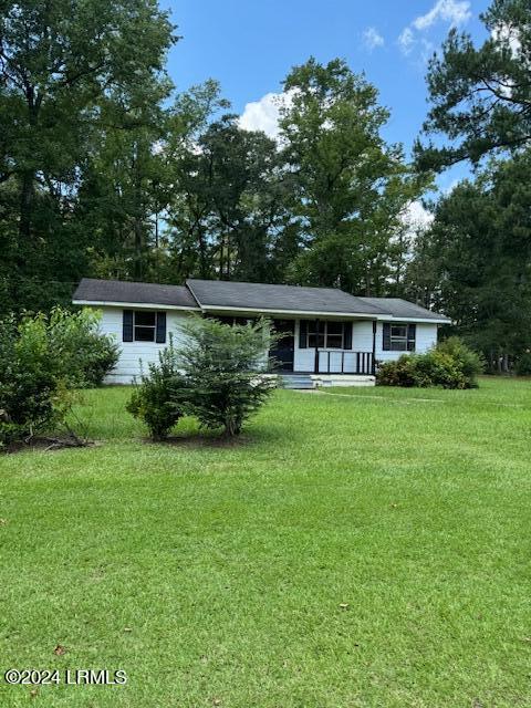 ranch-style house with covered porch and a front lawn