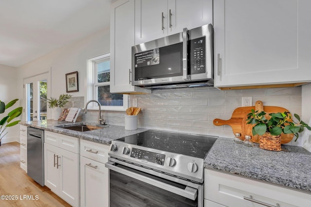 3001 N St, Beaufort, SC 29902 - kitchen with appliances with stainless steel finishes, a sink, white cabinets, and light stone counters