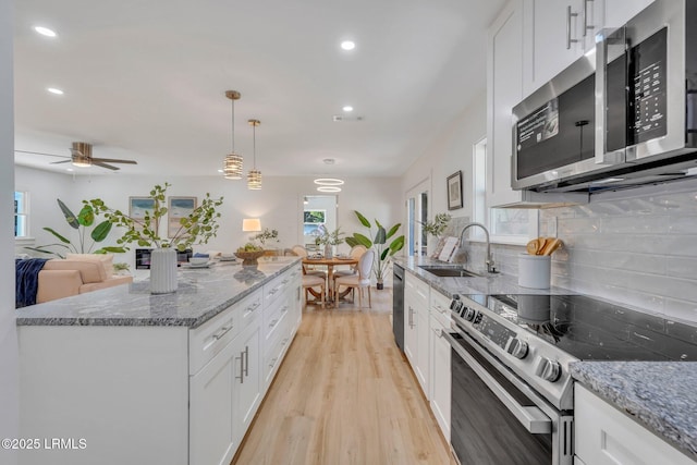 3001 N St, Beaufort, SC 29902 - kitchen featuring stainless steel appliances, a sink, light wood-type flooring, white cabinets, and backsplash