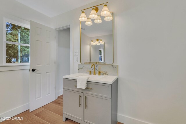3001 N St, Beaufort, SC 29902 - bathroom featuring wood finished floors, baseboards, vanity, tasteful backsplash, and a chandelier
