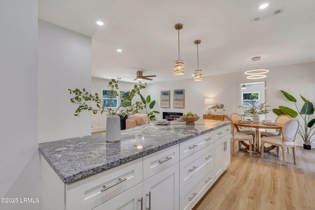 3001 N St, Beaufort, SC 29902 - kitchen featuring light wood-style floors, white cabinets, ceiling fan, recessed lighting, and hanging light fixtures