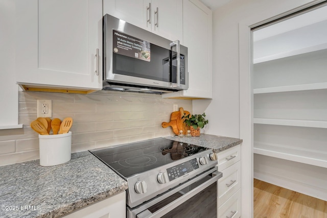 3001 N St, Beaufort, SC 29902 - kitchen with stainless steel appliances, white cabinetry, light stone countertops, tasteful backsplash, and wood finished floors