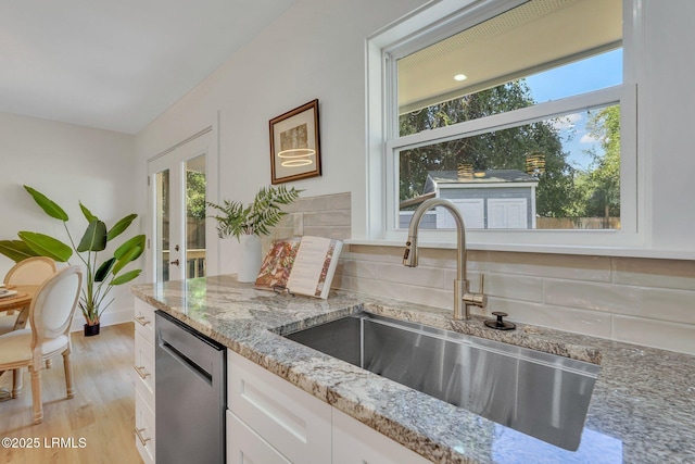 3001 N St, Beaufort, SC 29902 - kitchen featuring stainless steel dishwasher, a sink, light stone countertops, and decorative backsplash