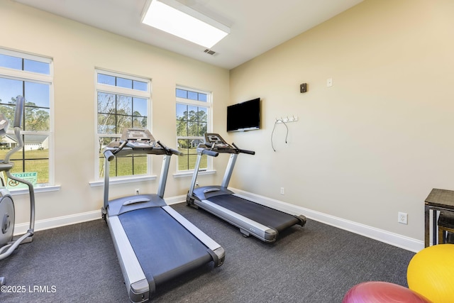 exercise room with visible vents, baseboards, and plenty of natural light