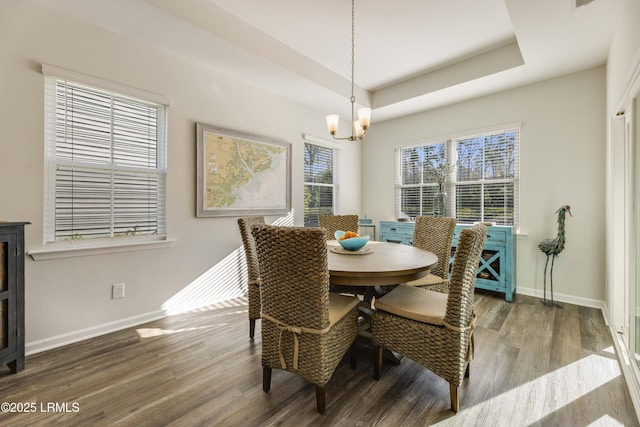 dining space featuring baseboards, a notable chandelier, a wealth of natural light, and wood finished floors