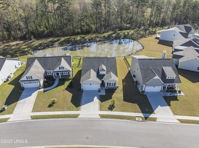 birds eye view of property with a water view, a residential view, and a forest view