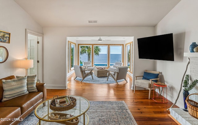 living room featuring hardwood / wood-style floors, vaulted ceiling, and ceiling fan