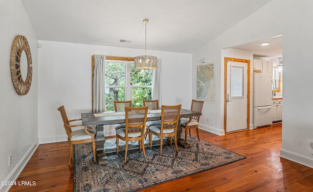 dining area featuring lofted ceiling and wood-type flooring