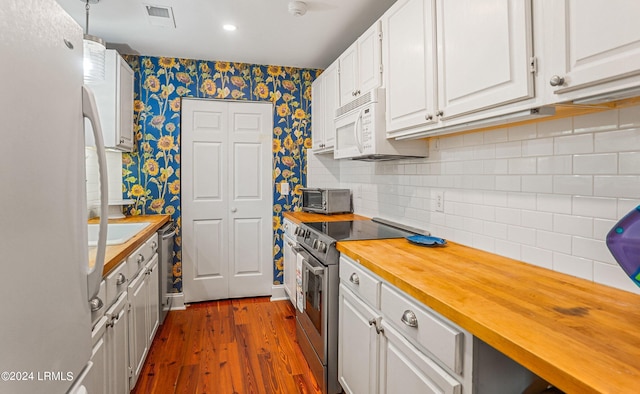 kitchen featuring dark wood-type flooring, butcher block counters, decorative light fixtures, white appliances, and white cabinets