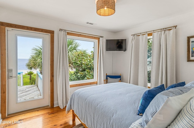 bedroom featuring light hardwood / wood-style floors and a water view