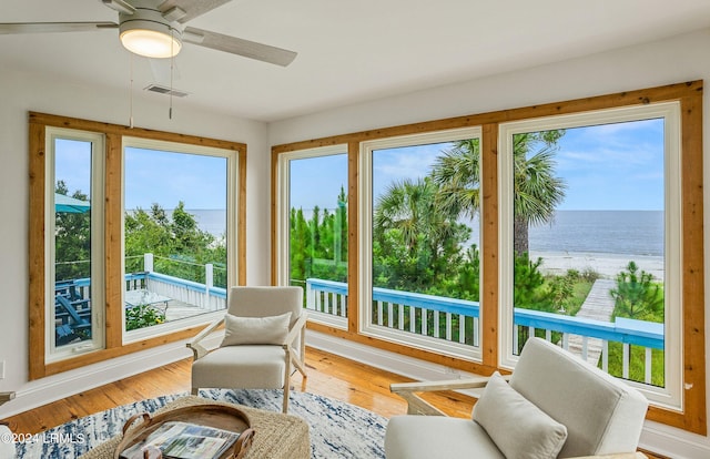 sunroom / solarium featuring a water view, a wealth of natural light, and ceiling fan