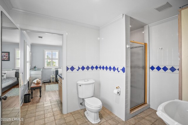 1 Scallop Ct, Harbor Island, SC 29920 - ensuite bathroom with tile walls, crown molding, a stall shower, and toilet