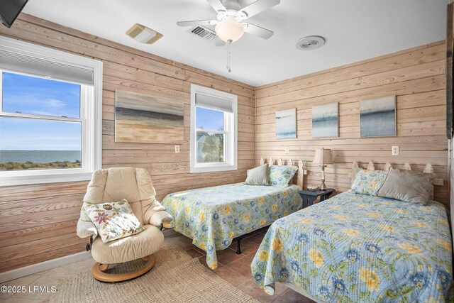 1 Scallop Ct, Harbor Island, SC 29920 - bedroom featuring tile patterned floors, wooden walls, and a ceiling fan