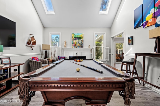 playroom featuring light hardwood / wood-style flooring, high vaulted ceiling, and a skylight