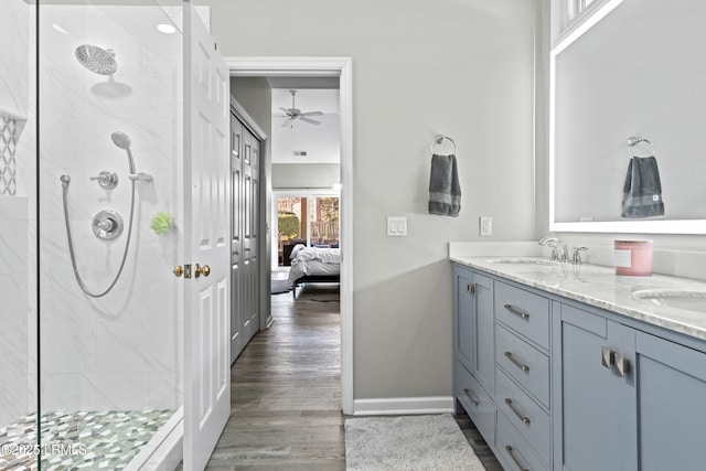 bathroom featuring vanity, wood-type flooring, ceiling fan, and a tile shower