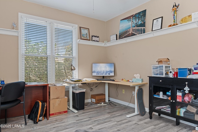 home office with light hardwood / wood-style floors