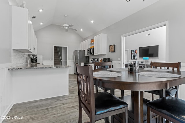 dining space featuring lofted ceiling, sink, light hardwood / wood-style flooring, and ceiling fan