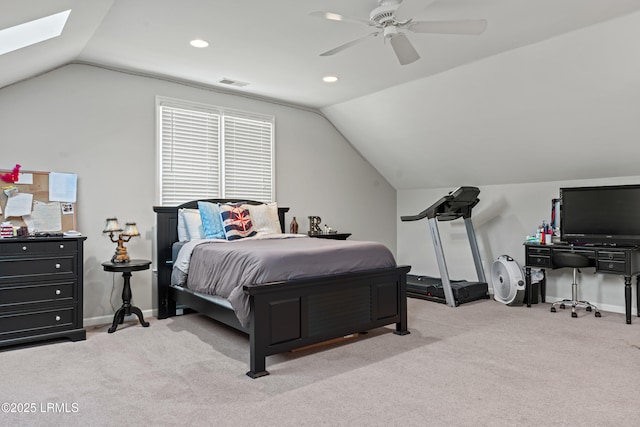 bedroom with ceiling fan, lofted ceiling with skylight, and light colored carpet