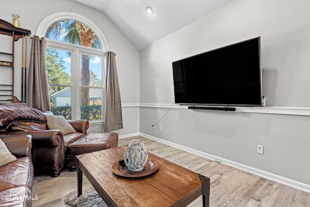 living room featuring lofted ceiling, a healthy amount of sunlight, and light hardwood / wood-style flooring