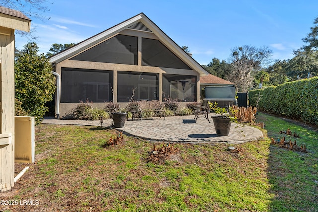 back of property with a yard, a patio area, and a sunroom