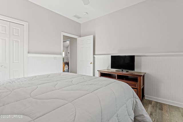 bedroom with hardwood / wood-style floors, ceiling fan, and a closet