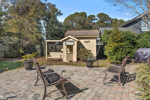 view of patio / terrace with a grill and a shed