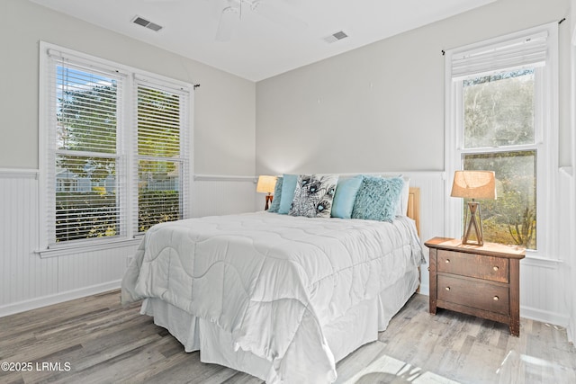 bedroom featuring multiple windows, ceiling fan, and light hardwood / wood-style floors