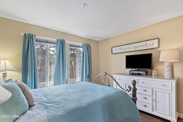 bedroom featuring access to exterior, dark wood-type flooring, and a textured ceiling